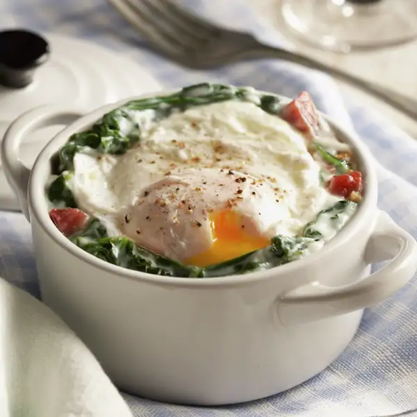La cena que nunca falla: cazuelitas de espinacas con bechamel y huevo poché