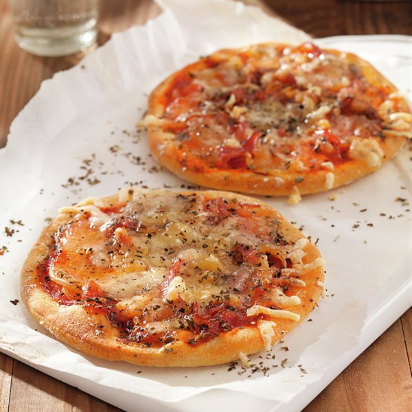 Mini pizza with ham, tomatoes and cheese