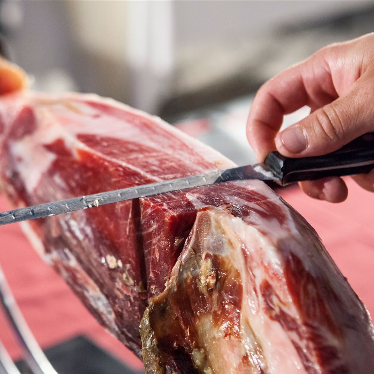 Cortando jamón con buen cuchillo y jamonero