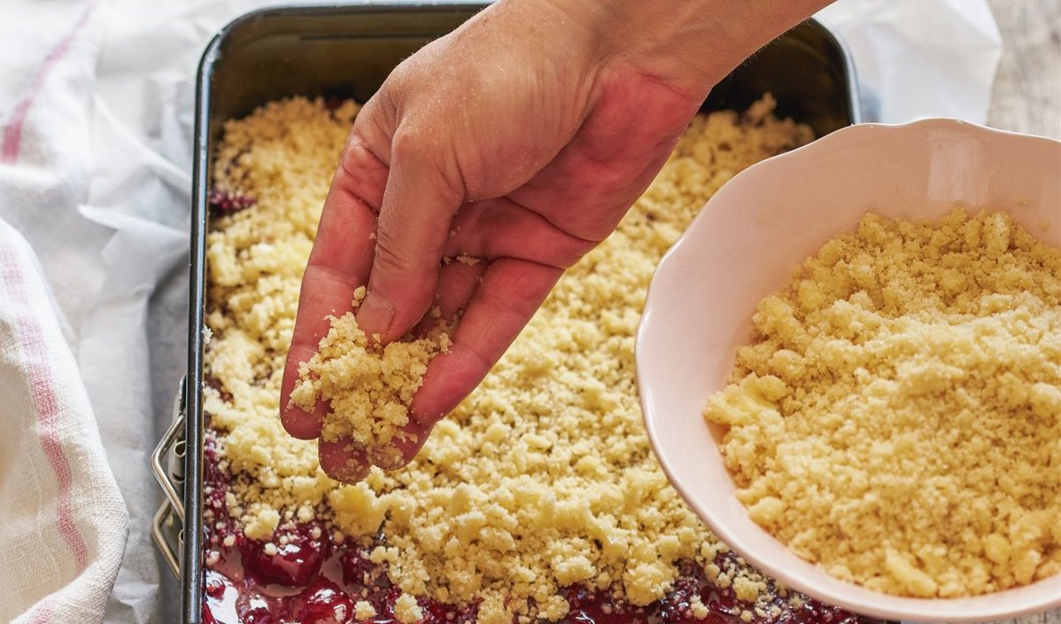 paso_a_paso_para_realizar_coca_crujiente_de_cerezas_repartir_las_migas_de_crumble_por_encima_de_la_compota_de_cerezas 00480963.jpg