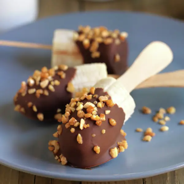 Plátano bañado en chocolate y crocanti, un postre con palito