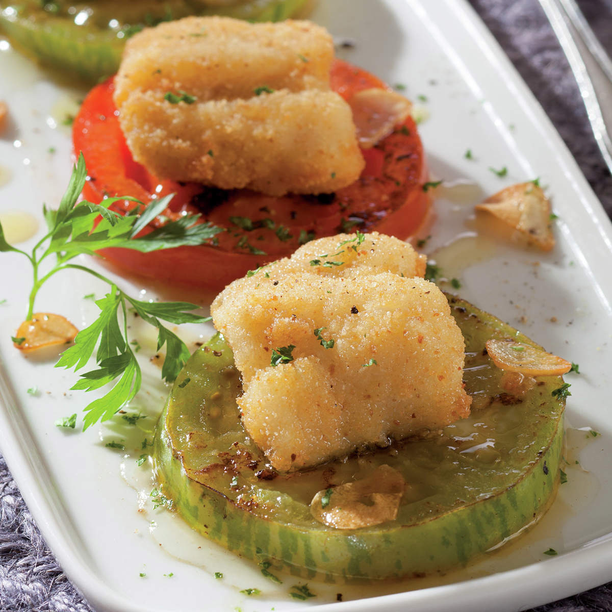 Pescadilla rebozada con tomates y perejil