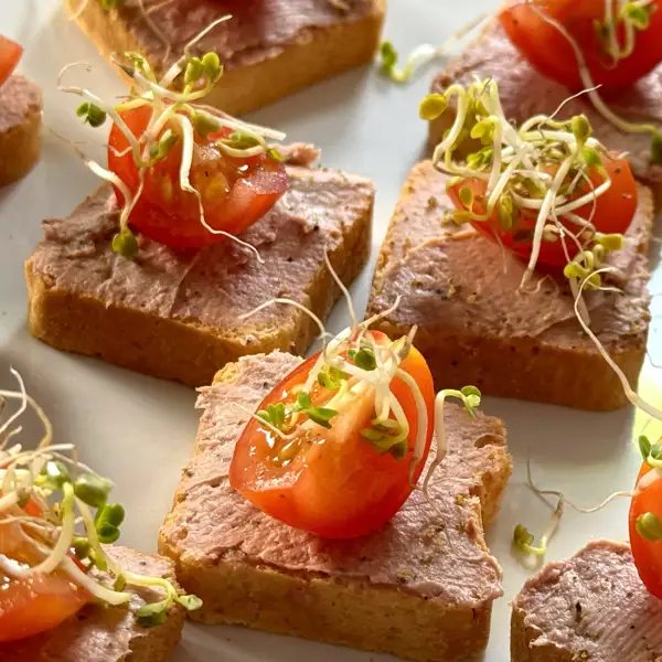 Canapé de paté de pimienta, tomate cherry y germinados