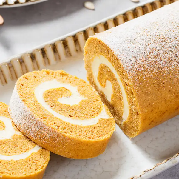 Brazo de gitano de bizcocho de calabaza relleno de crema de queso, un postre fácil y saludable