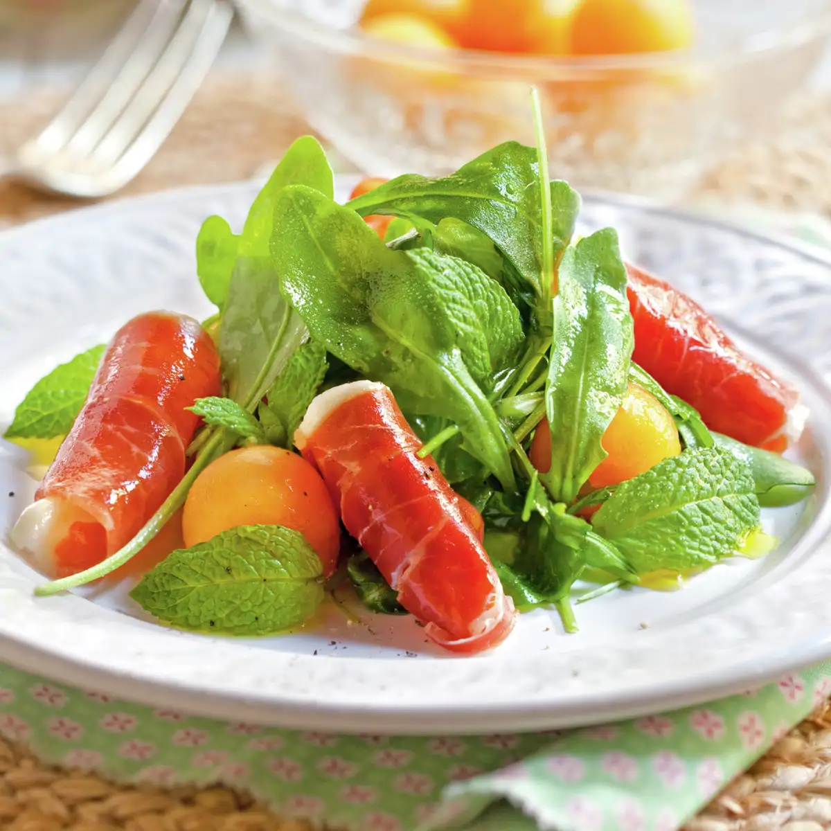 Ensalada de rúcula con melón y rollitos de jamón