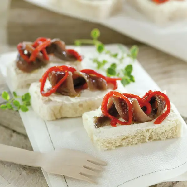 Bocaditos de pan de molde con queso crema, anchoa y pimiento asado, canapés superfáciles y ¡en 5 minutos!