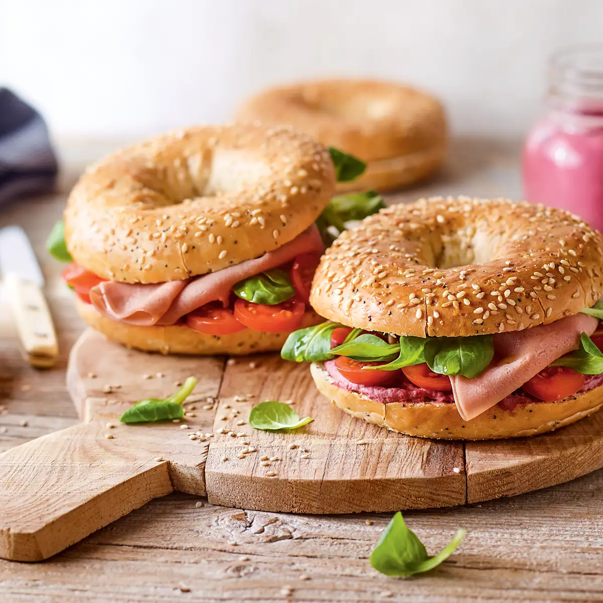 Bagel de hummus de remolacha, canónigos y tomatitos