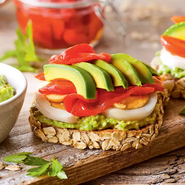 Cena rápida y proteica: tostas de avena con guacamole, huevo y pimientos