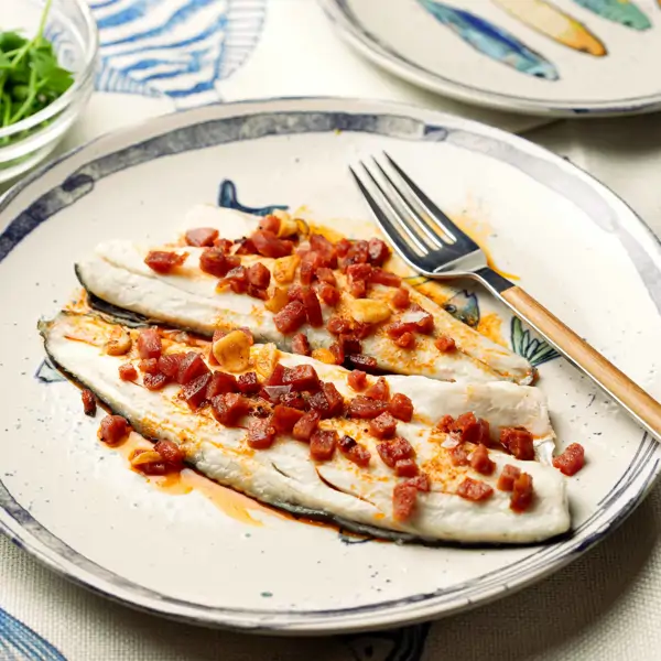 Lubina al horno rápida y fácil, la receta más jugosa con sofrito de salchichón ibérico, ¡irresistible!